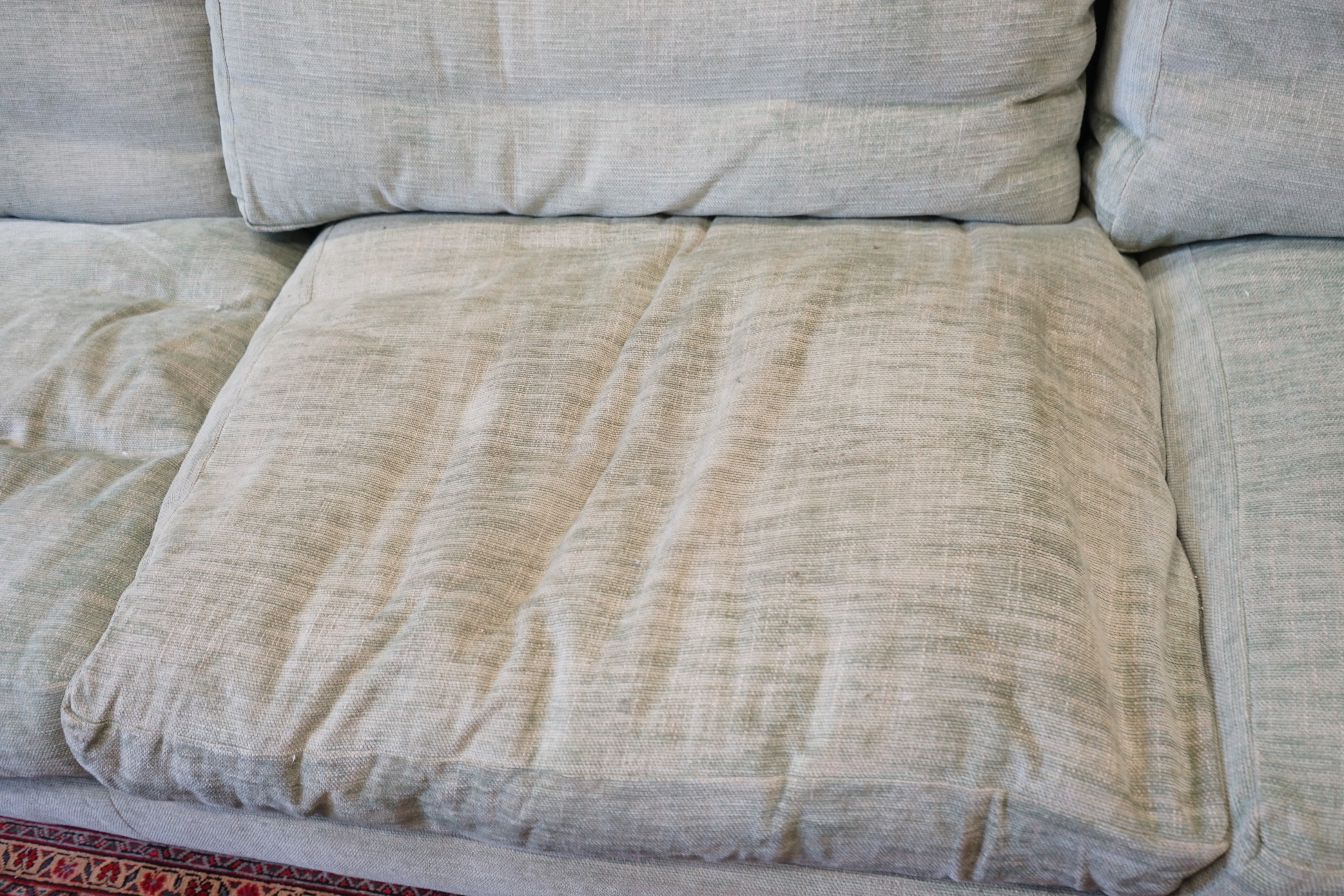 A large Howard style three seater settee upholstered in pale green fabric, length 300cm, depth 120cm, height 92cm